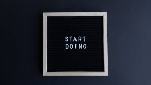 Black letter board with the motivational phrase 'Start Doing' in white text on a gray background.